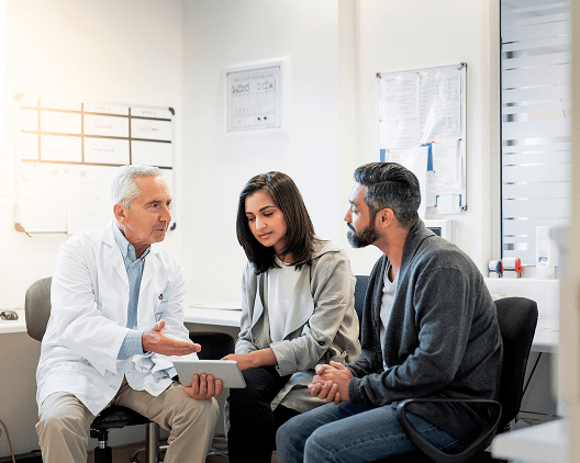 A healthcare provider, woman, and man having a conversation